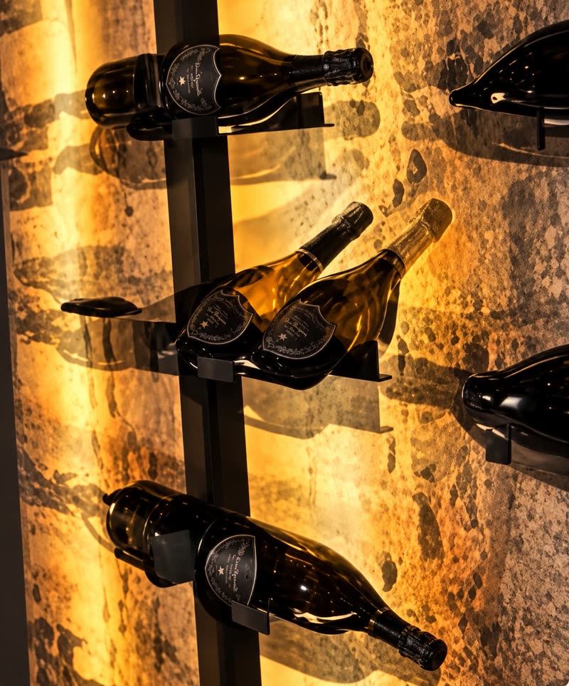 Bouteilles exposées sur un mur de pierre éclairé